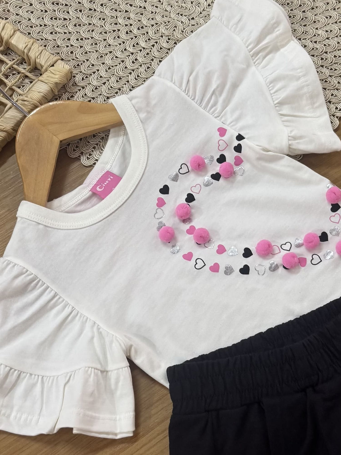 Conjunto Infantil Cinti Verão com Shorts Saia Preto e Blusa Branca Coração Pompon