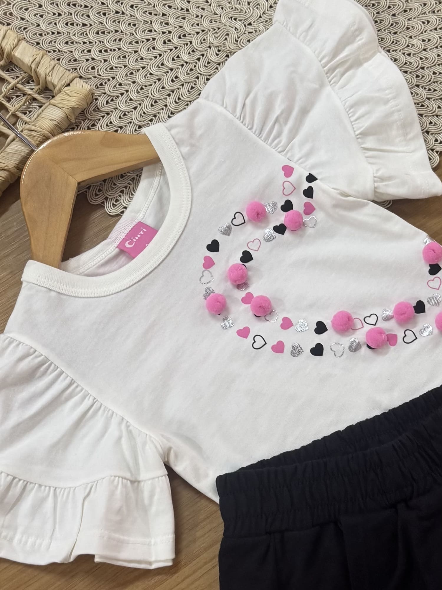 Conjunto Infantil Cinti Verão com Shorts Saia Preto e Blusa Branca Coração Pompon