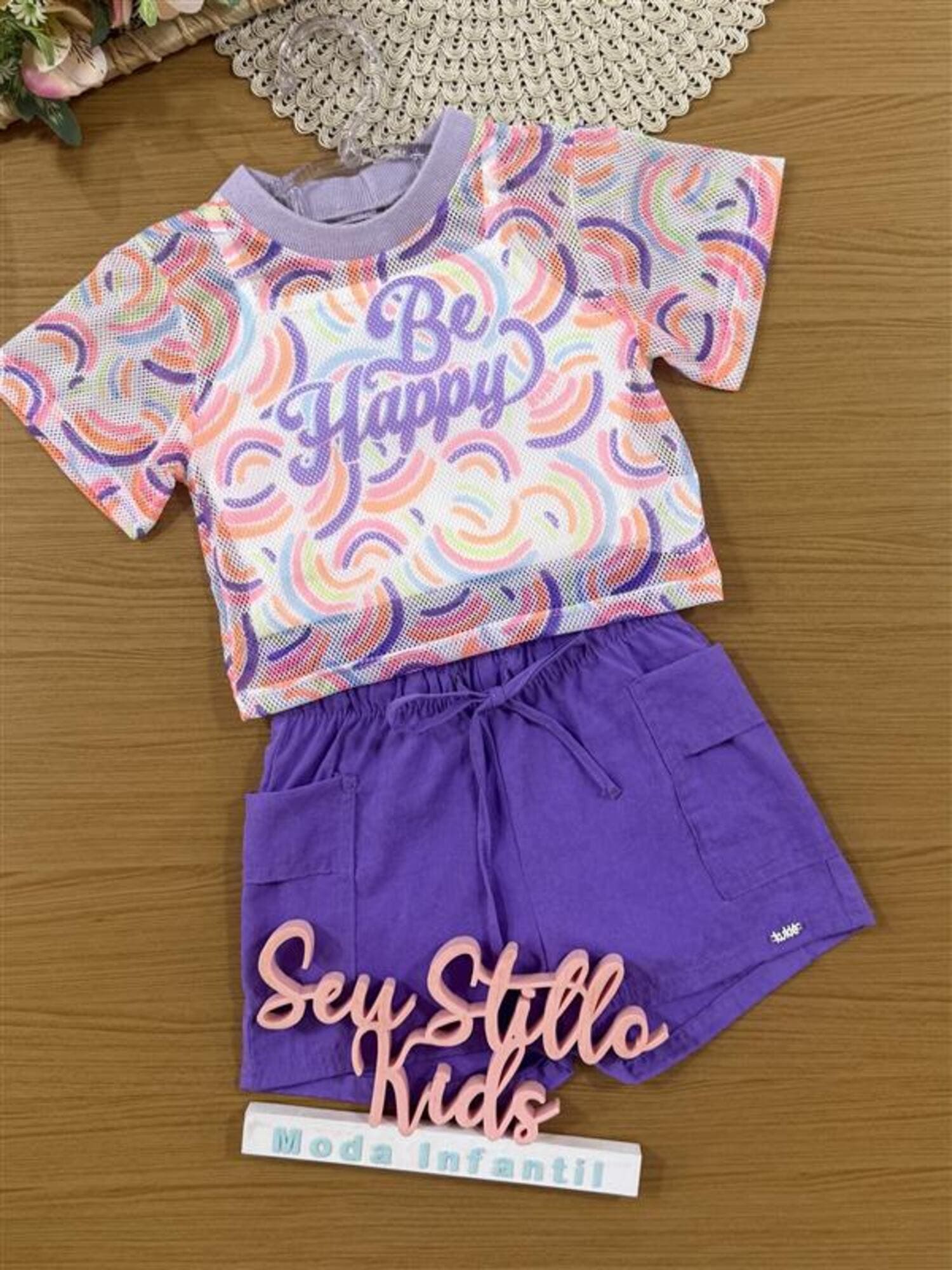Conjunto Infantil Kukiê Verão com Shorts Roxo, Top e Sobreposição em Tela Arco-íris